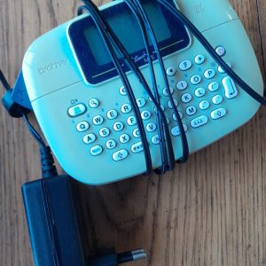The Brother P-Touch PT-M95 is a compact, handheld label maker designed for quick and easy organization at home, school, or the office. It features a QWERTY keyboard and prints up to two lines of text on 9mm or 12mm non-laminated M-series tapes.